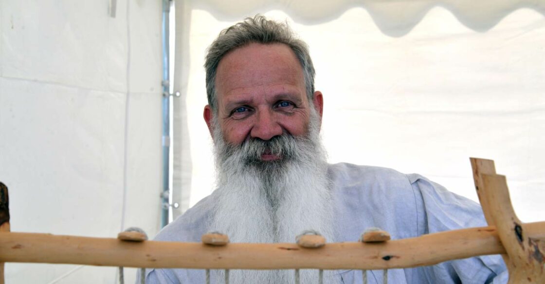 Buchbinder Martinus Janssen strahlend bei der traditionellen Arbeit eines Buchbinders.
