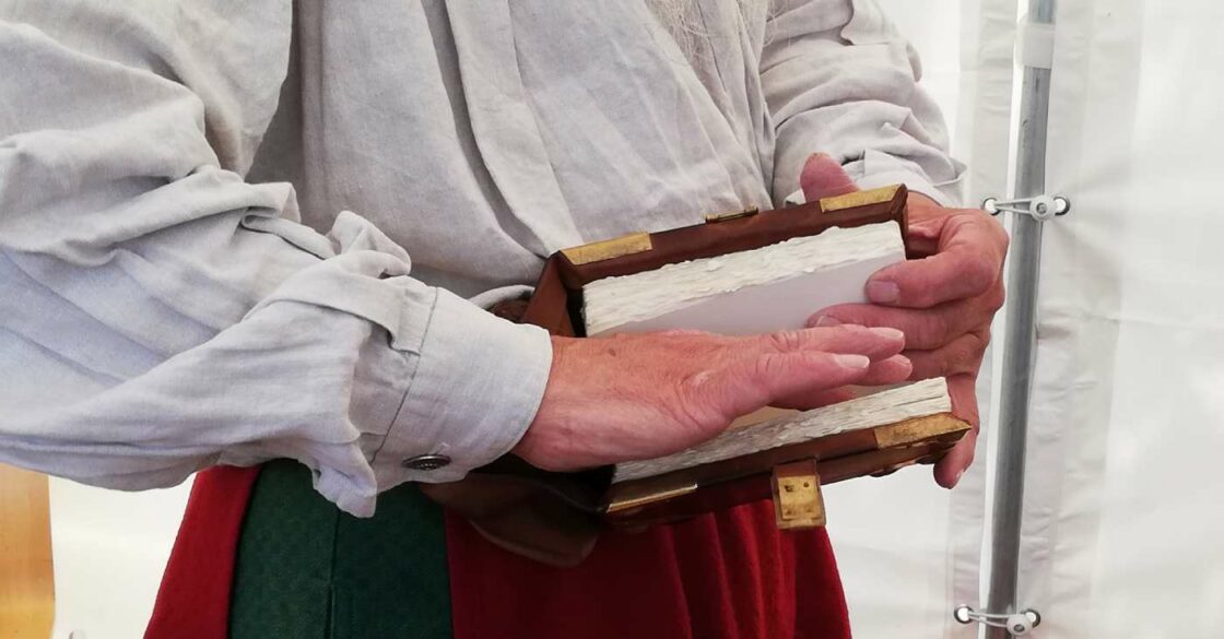 Buchbinder und Künstler Martinus Janssen blättert durch sein Gürtelbuch